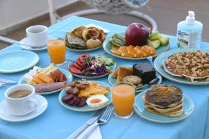 una mesa azul cubierta con platos de desayuno en Klinakis Beach Hotel, en La Canea