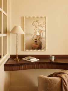 a mirror on a wall above a table with a lamp at No 42 by GuestHouse, Margate in Margate