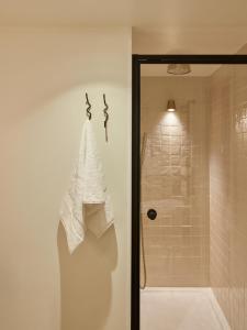 a shower with a towel hanging on a wall at No 42 by GuestHouse, Margate in Margate