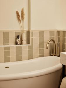 a bathroom with a white tub and a sink at No 42 by GuestHouse, Margate in Margate