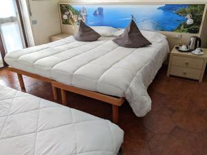 a large white bed with pillows on top of it at Hotel Montecarlo in Castellanza