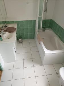 un bagno con vasca, lavandino e WC di Relais de la tour a Termes-dʼArmagnac