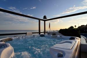 a jacuzzi tub on a balcony with the ocean at Hotel Cavalluccio Marino in Santa Marinella
