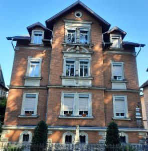 a tall brick building with windows and a statue in front at Ferienwohnung An der Itz in Coburg