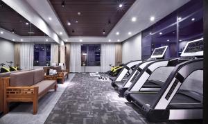 a gym with a row of treadmill machines in a room at Wing Hotel Guilin - Central Square in Guilin