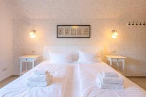 Un dormitorio con una cama blanca con toallas. en Kietz-Mole mit Müritzblick en Waren