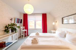 1 dormitorio con 2 camas y una ventana con cortinas rojas en Kietz-Mole mit Müritzblick en Waren