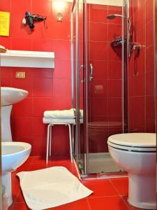 baño rojo con ducha y aseo en Hotel Montecarlo, en Castellanza