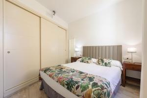 1 dormitorio con 1 cama grande y escritorio en Green-Apartments Giralda Views, en Sevilla