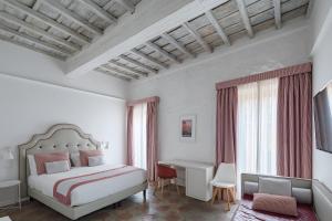 ein Hotelzimmer mit einem Bett, einem Schreibtisch und einem Tisch in der Unterkunft Palazzo Lupardi Relais in Rom
