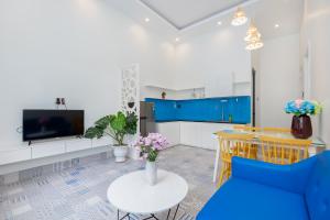 a living room with a blue couch and a table at Sea House Hotels and Apartments in Vung Tau