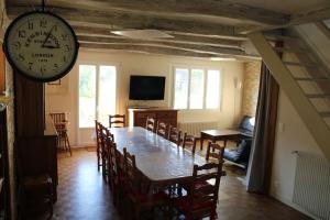 une salle à manger avec une table et une horloge murale dans l'établissement Gîte Natur'Amis, à Rivarennes