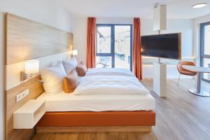 a bedroom with a large bed with a flat screen tv at VR-Serviced Apartments Gerstungen in Gerstungen