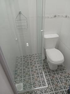 uma casa de banho branca com um WC e um chuveiro em Casarão Hostel & Quartos Privados em Florianópolis