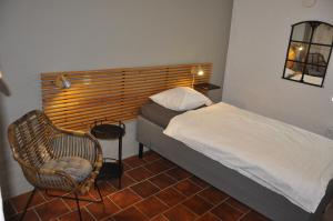 una piccola camera con letto e sedia di Hylteberga Gård Bed & Breakfast a Skurup