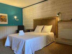 Un dormitorio con una cama con una manta blanca. en La maison de gravies, en Anduze