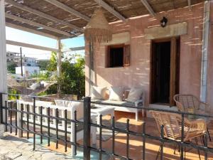 a patio with a couch and chairs on a balcony at Villa archontiko in Kamilari
