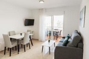 uma sala de estar com um sofá e uma mesa em Nacavi Albir Aparthotel em Albir