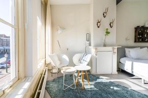 een kleine kamer met een bed en twee stoelen en een tafel bij Nr 19 Bed and Bubbels in Middelburg