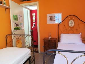 a bedroom with two beds and an orange wall at Il Ritiro Estivo in Rosignano Solvay