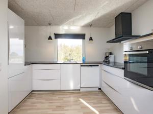 una cocina con armarios blancos y una ventana en 10 person holiday home in Bl vand, en Ho