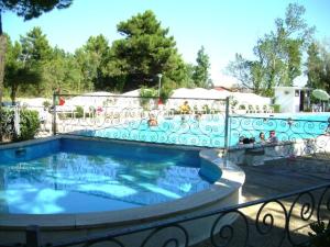ein Schwimmbad mit einem Zaun um ihn herum in der Unterkunft Residence El Patio in Rosolina Mare