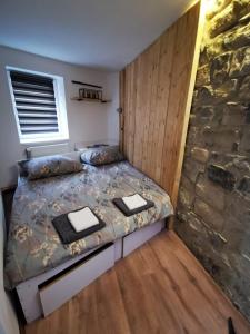 1 dormitorio con cama y pared de piedra en Second chance apartment en Choteč