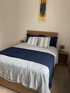 a bedroom with a bed with blue and white sheets at ARDUTHIE STREET in Stonehaven