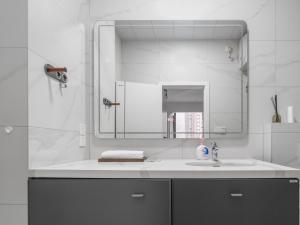 La salle de bains blanche est pourvue d'un lavabo et d'un miroir. dans l'établissement Somewhere Else B&B, à Nan'an