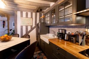cocina con armarios de madera y encimera en La Tour aux Grains chambres autonomes en Romorantin