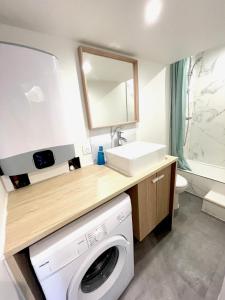 een badkamer met een wasmachine en een wastafel bij Saint Leonard in Nantes