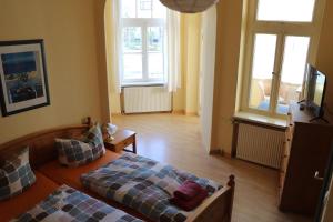 a living room with two beds and a television at Pension Lotte in Kühlungsborn