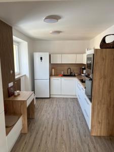 a kitchen with white cabinets and a white refrigerator at Apartmán MD in Žacléř