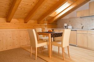 eine Küche mit einem Tisch und Stühlen im Zimmer in der Unterkunft Gästehaus Lödermann in Garmisch-Partenkirchen