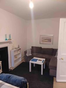 a living room with a couch and a coffee table at The Wee Room -Stay Where All St Andrews is on the Doorstep! in Fife