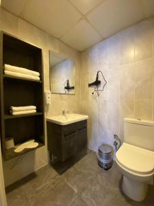 a bathroom with a sink and a toilet and a mirror at Pin Suite Hotel in Kırac