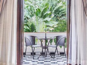 a patio with a table and chairs on a balcony at Chateau d'Angkor La Residence in Siem Reap