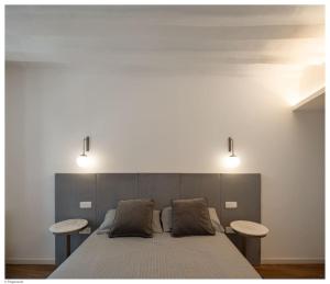 Un dormitorio con una cama con dos mesas. en Casa del Encierro - Estafeta en Pamplona