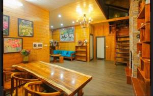 a dining room with a wooden table and a blue couch at Mimosa Villa in Vĩnh Phúc
