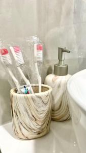 - un porte-brosse à dents en bois sur un comptoir de salle de bains à côté d'un lavabo dans l'établissement La Casa de Armenie, à Erevan