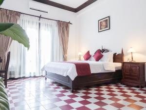 a bedroom with a bed and a checkered floor at Chateau d'Angkor La Residence in Siem Reap