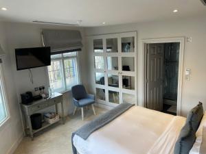 Dormitorio con cama, escritorio y TV en The Bridge Pub & Rooms, en Londres