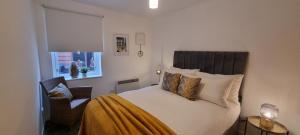 um quarto com uma cama, uma cadeira e uma janela em Merchantcityflat em Glasgow