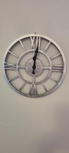 une horloge est suspendue sur un mur blanc dans l'établissement Merchantcityflat, à Glasgow