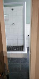y baño con ducha y azulejos blancos y negros. en Fabulous guest house en Pietermaritzburg
