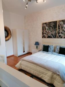 a bedroom with a large bed and a painting on the wall at CASA VACANZA IL SORRISO DEL LAGO in Avigliana
