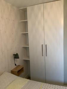 a bedroom with a white cabinet and a bed at Atelier Zonnehoek in Bergen