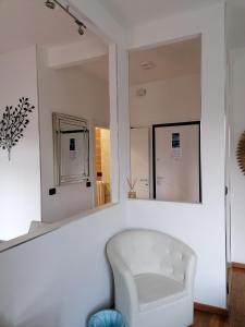 a white chair in a room with a mirror at CASA VACANZA IL SORRISO DEL LAGO in Avigliana