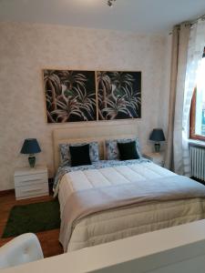 a bedroom with a large bed with two lamps at CASA VACANZA IL SORRISO DEL LAGO in Avigliana