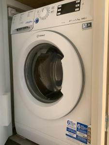 uma máquina de lavar roupa branca sentada num quarto em Atelier Zonnehoek em Bergen